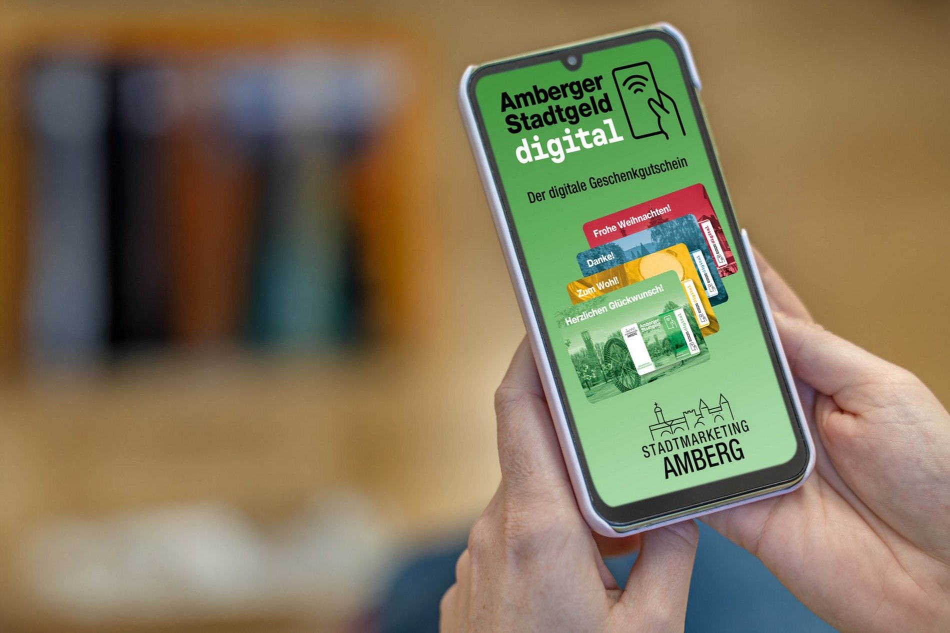 Das Foto zeigt ein Handy mit der Werbung für das digitale Stadtgeld auf dem Display.